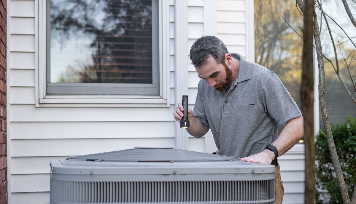 HVAC services in the GTA technician inspecting a central air conditioner